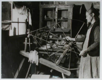 "Another view of Mrs. James Watson at her spinning wheel in her mountain cabin near Gatlinburg, Tennessee.", 11/14/1933