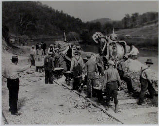 "Mixing the first batch of concrete for Crib #1 on the heavy duty bridge at the site of Norris Dam, just below the Dam itself.", 11/01/1933