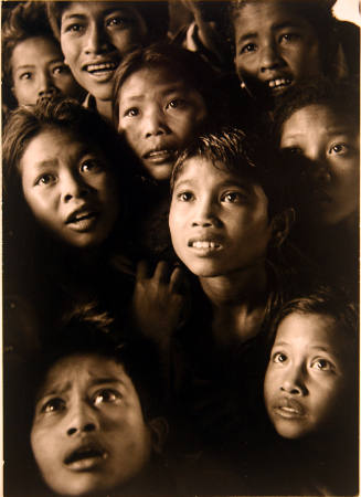 Children looking at photographs taken in their village ten years earlier, Bayung Gedé, Bali, Indonesia