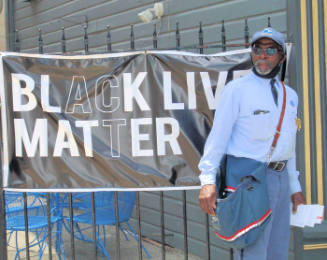BLM Sign and Postal Man
