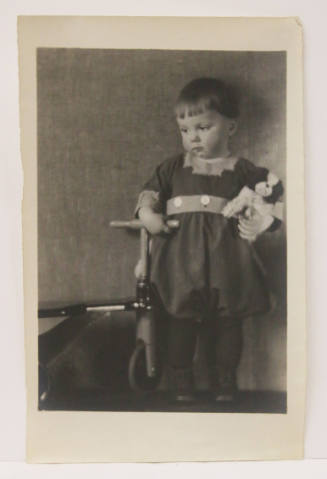 Portrait of a Child with a Scooter and Stuffed Animal